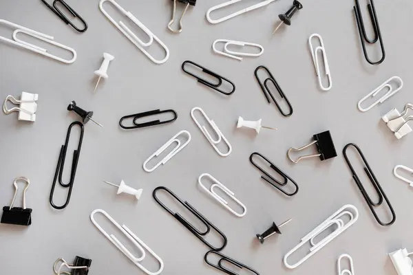 collection of various type of paper clips over grey background