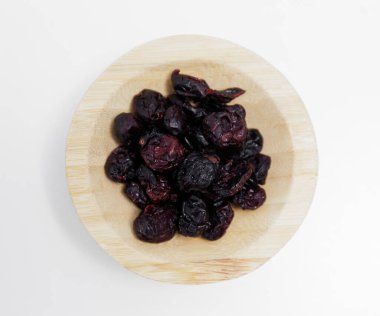 Beyaz masa arkasında kurumuş kızılcık kasesi.