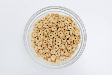 Beyaz arka planda cam kasede servis edilen gevreklerin üst görüntüsü