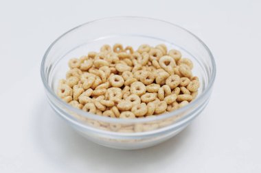 Mısır gevrekleri beyaz arka planda cam kasede servis ediliyor.