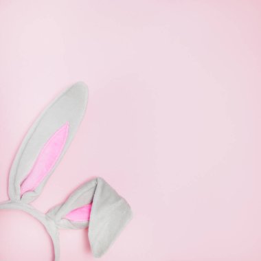 Paskalya için tavşan kulaklığı. Fotokopi alanı olan pembe bir arka planda.