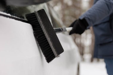 Erkek ellerindeki fırçayı kapat. Kar yağdıktan sonra arabayı temizle.