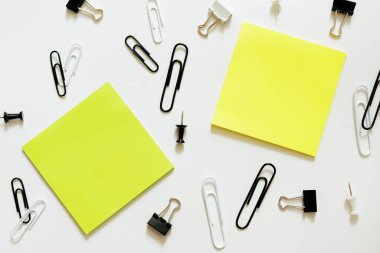 Beyaz arkaplan üzerinde iki yapışkan not ve ataç