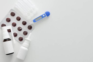 Dijital termometre düzlüğü, ilk yardım kiti, burun spreyi ve kopyalanmış haplar.