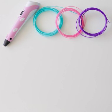 Kopyalama alanı olan beyaz masadaki renkli plastik filament 3d kalem ve kit