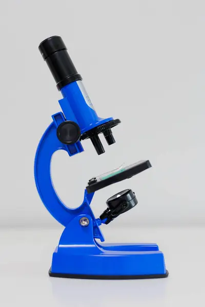 Vue Latérale Microscope Bleu Sur Table Blanche Photo De Stock