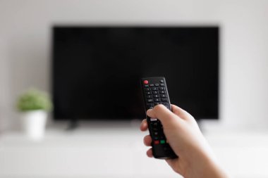 Arka planda siyah uzaktan kumandayla ve televizyonla elinizi kapatın