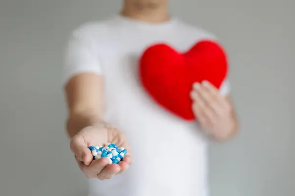Man Holding Red Heart Pillow Blue Pills Hands Copyspace Royalty Free Stock Images