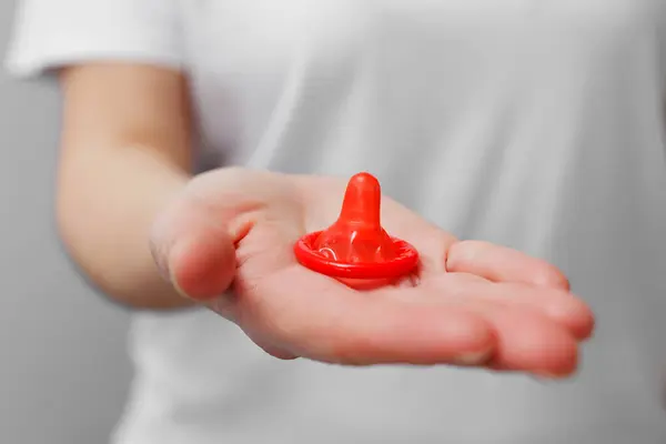 닫다 의 여자 손 보유 열린 빨간 콘돔 로열티 프리 스톡 사진