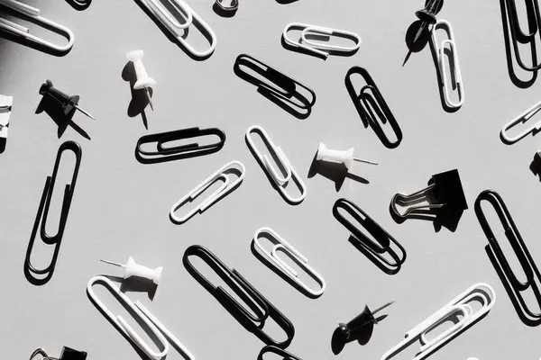 close up of various type of paper clips over grey background