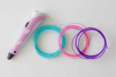 3D kalem, beyaz masadaki renkli plastik iplik takımı