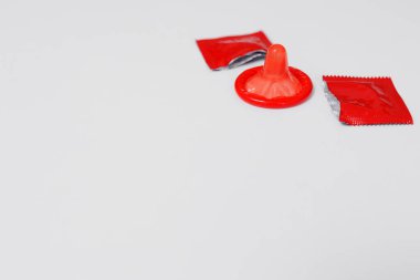 Telif alanı olan beyaz arkaplandaki kırmızı açık prezervatifi kapat