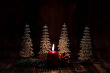 Christmas greeting card - White burning candle with natural decoration on rustic light wood - Merry Christmas and happy new year