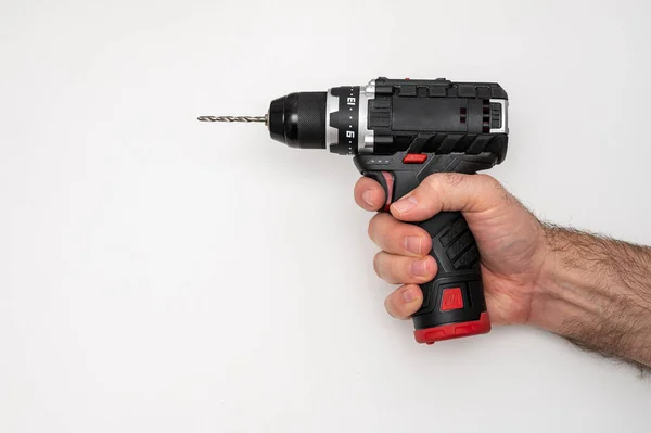 Bir işçi matkap tutuyor. Kablosuz matkap. Aletlerle çalışan bir tamirci. 