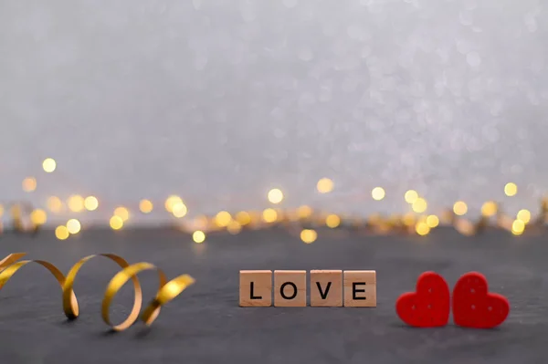 The word love on wooden blocks. congratulations on Valentine\'s day. The theme of love. Wooden blocks for letters. Love, positive emotions. Wooden cubes with a word. Banner. Selective focus and shallow depth of field
