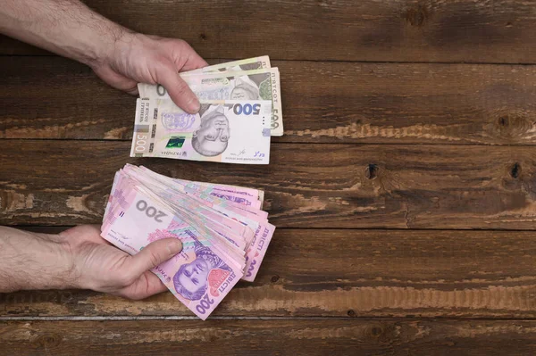 Ukrayna 'da düşük maaş kavramı. Bir adamın ellerinde Hryvnia.