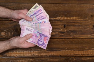 A man holds in his hands his earnings, money for a month of work.