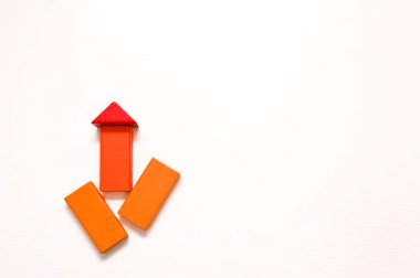 Beyaz zemin üzerinde kırmızı ve turuncu oklar şeklinde tahta şekilli küpler. Çocuklar için eğitici oyunlar. Kavramları. boş boşluk