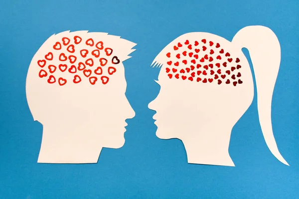 The concept of love between a man and a woman. Silhouette of female and male head with hearts inside
