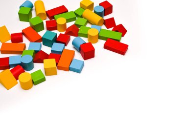 Colorful wooden bricks of different shapes on a white wooden table. The concept of learning. copy space