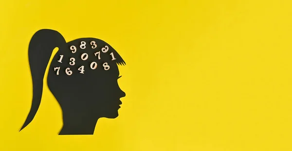 Silhouette of a woman\'s head with numbers in the brain. concept on a yellow background with mock up. digitization of the brain