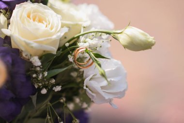 Evlilik yüzükleri bir buket beyaz çiçekte..
