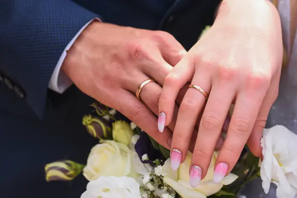 bride and groom hands with gold wedding rings