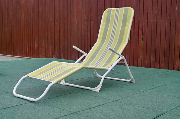 Empty deck chair or chaise longue. Concept of recreation, tanning in yard on sunbed.