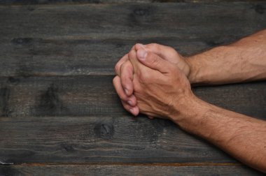 Ahşap bir masanın üzerinde katlanmış erkek elleri. Pazarlık konsepti, röportajlar, toplantılar. Bir işveren ya da yöneticiyle bir randevuda. Yüzü olmayan. Tanınmaz halde. Yakın plan.