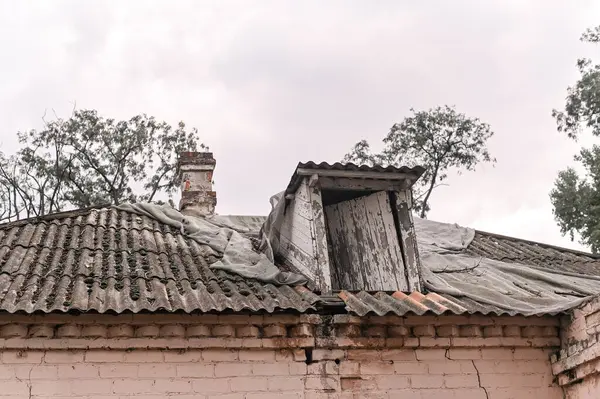 Damaged roof and wall in an old collapsing house.
