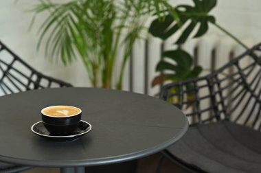 Siyah bir masada siyah bir fincan kahve.