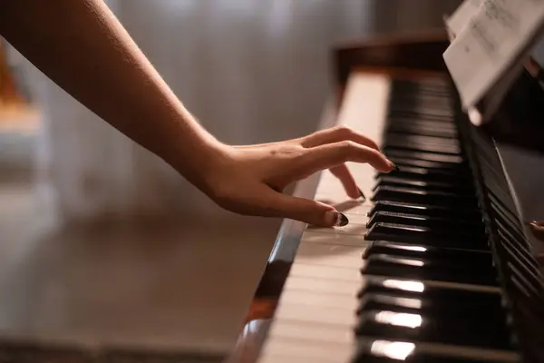 a pianist\'s hand is on the piano keys