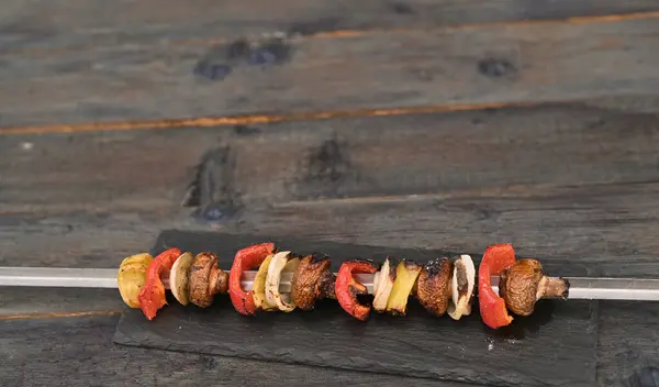 vegetable kebab on a skewer on a wooden table