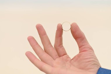 Damadın elinde gelin için bir nişan yüzüğü. Yakından altın bir yüzük..