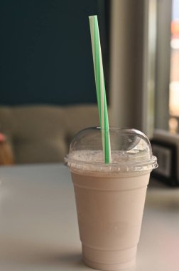 Masadaki bardakta bir milkshake. dikey