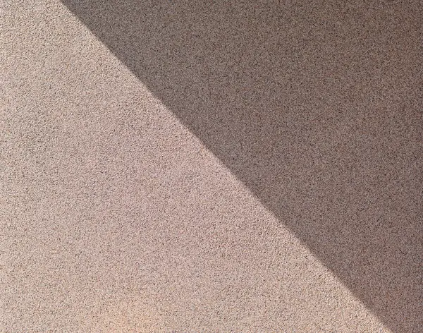 a diagonal shadow on the wall. finishing with granite chips