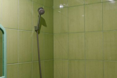 Banyoda duş başlığı. yeşil seramik fayanslar