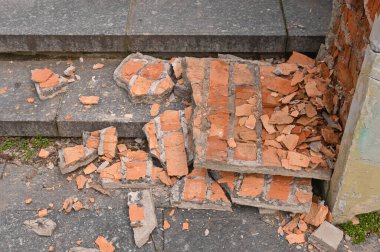 Tuğla duvarın parçaları parçalanıyor.