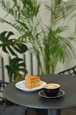 Masanın üzerinde bir parça kek olan kahve.