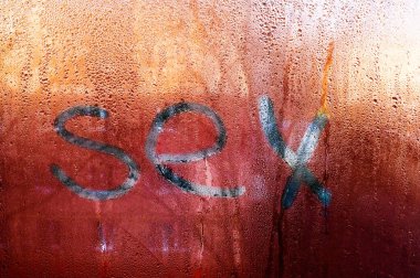 Seks kelimesi ıslak pencere camında yazılıdır. Penceredeki buğulanma.