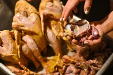 Tavuk ve güvercin eti. Ellerinde sakatat olan yolunmuş kümes hayvanları.. 