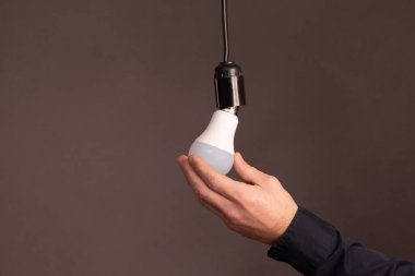 Bira elleri enerji tasarrufu sağlayan bir LED ampulü vidaladı. Enerji tasarrufu fikri