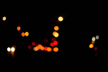 Bokeh 'in geçmişi. Koyu arkaplanda kırmızı ve sarı ışıklar