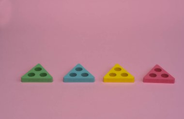 Pembe arka planda dört farklı üçgen. Konsept