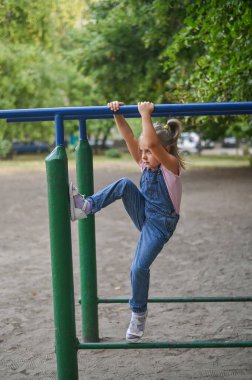 Düz olmayan barlarda bir kız oynuyor. dikey