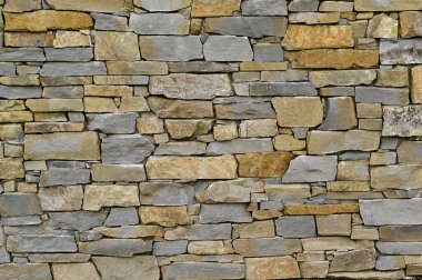 Farklı şekillerde taşlardan yapılmış tuğla bir duvar. arkaplan