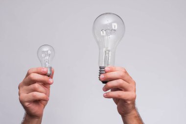 Ellerinde parlak ampuller var. büyük ve küçük lamba