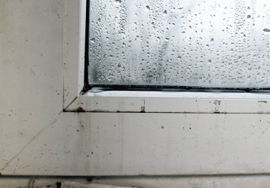 Islak bir pencere. Bardaktaki su damlacıkları