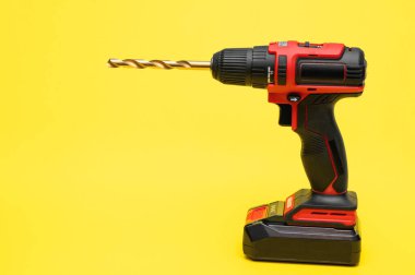 Sarı arka planda matkabı olan elektrikli tornavida.