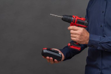 Adamın biri kablosuz tornavidaya pil takıyor..